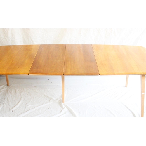 627 - Ercol light elm Grand Windsor extending dining table, with hinged undertier extension leaf, L152cm u... 