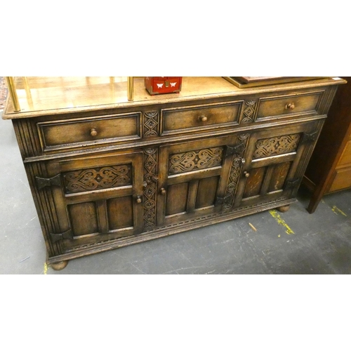 482 - Large oak, Priory style sideboard with three drawers and carved panels to doors.H.90cm x W.152cm x D... 