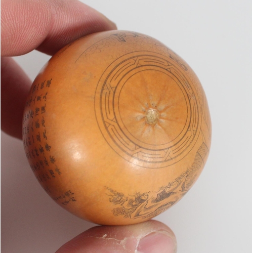 559 - Very finely carved near spherical gourd with inked incised lines depicting a man with a dog’s ... 