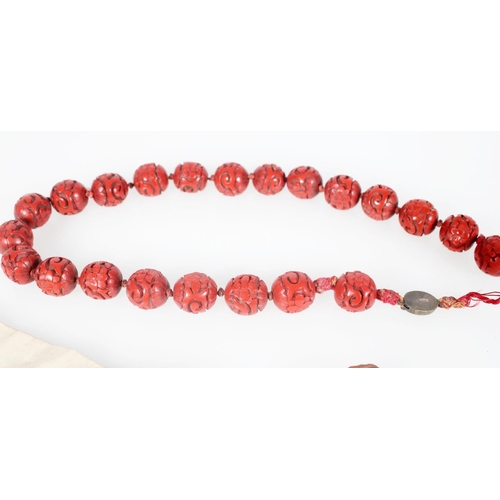 575 - Chinese jewellery including a string of 22 early 20th century cinnabar lacquer beads with silver clo... 