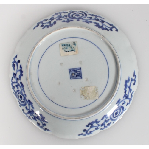 576 - 18th century Japanese Arita blue and white dish decorated with a figure in a landscape beneath a flo... 