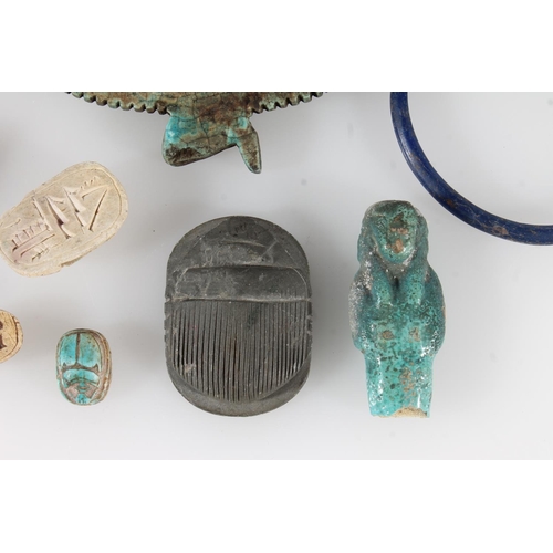 486 - Egyptian faience style winged goddess, 7.5cm long, two bangles, a small ushabti figure (af), four sc... 