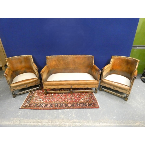 420 - 20th century Arts and Crafts two seater leather sofa along with two leather tub armchairs of studded... 