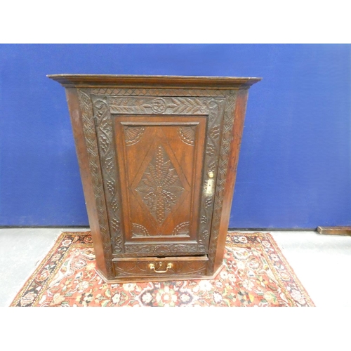 427 - 18th century oak corner cupboard, the carved panel door enclosing three shelves. Height 105cm, Width... 