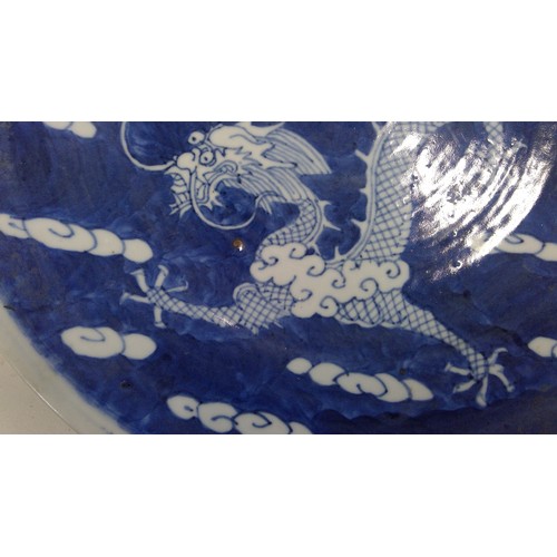 532 - Chinese blue and white porcelain dragon plate, late Qing period, the five clawed dragon amongst clou... 