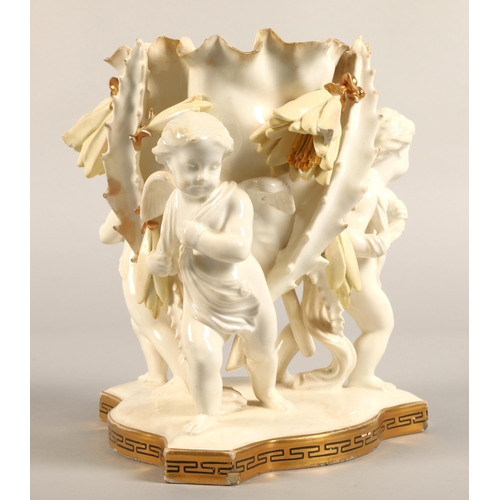 232 - Moore Bros vase, three cupids supporting a bowl,20cm high.