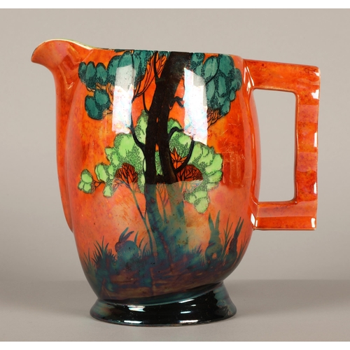 26 - Carlton Ware lustre jug decorated in oranges featuring trees and rabbits. 20cm hig