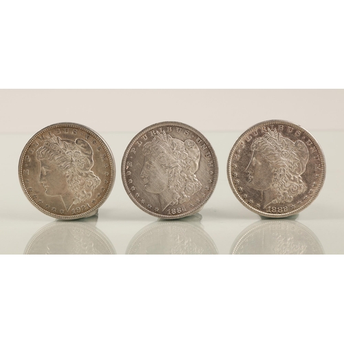 54 - Three silver dollars, 80g, 1884, 1888, and 1921, mint marks of 'O' on 1884 and 'S' on 1882