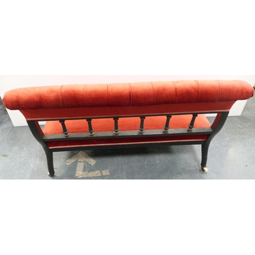 109 - Late Victorian aesthetic ebonised boudoir sofa, upholstered in later red button-back Dralon, with sp... 