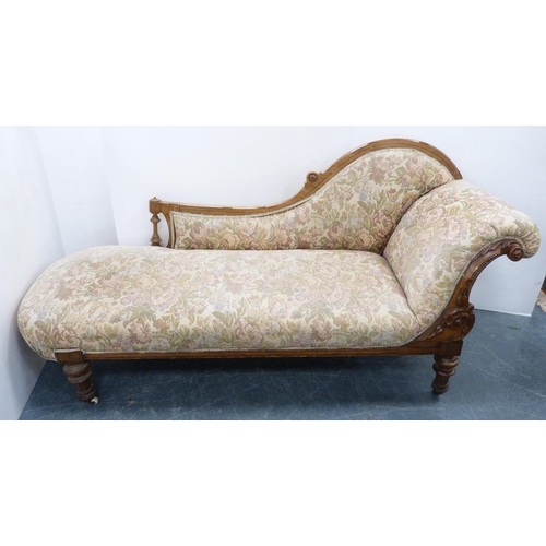 110 - Late Victorian walnut scroll-back chaise longue, upholstered in later floral fabric, carved with app... 