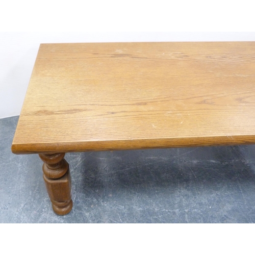 111 - Heavy oak coffee table with rectangular top on turned and block supports, 53cm high and 140cm wide.