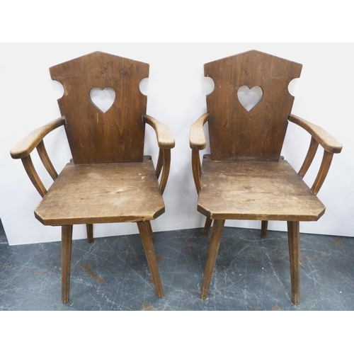 116 - Pair of Arts & Crafts-style rustic pine armchairs, possibly Continental, each with a stylised he... 