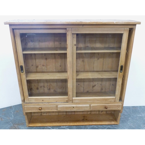 118 - Farmhouse pine pantry cupboard with twin sliding glazed doors enclosing a shelved interior, above th... 