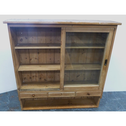 118 - Farmhouse pine pantry cupboard with twin sliding glazed doors enclosing a shelved interior, above th... 