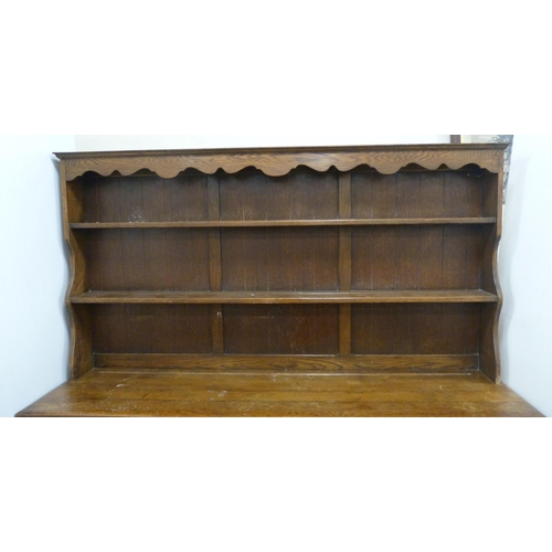 184 - Late 19th/early 20th century oak dresser with shaped apron to the top above two open shelves, the ba... 