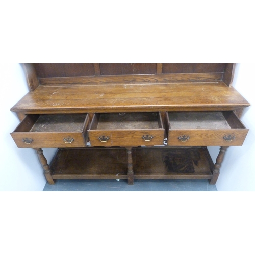 184 - Late 19th/early 20th century oak dresser with shaped apron to the top above two open shelves, the ba... 