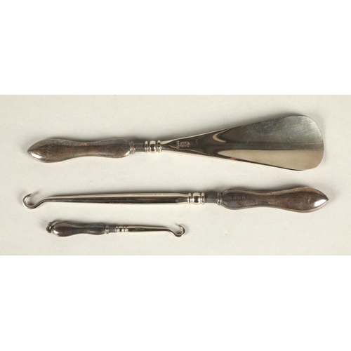 263 - Silver handled shoe horn and two button hooks, cased.