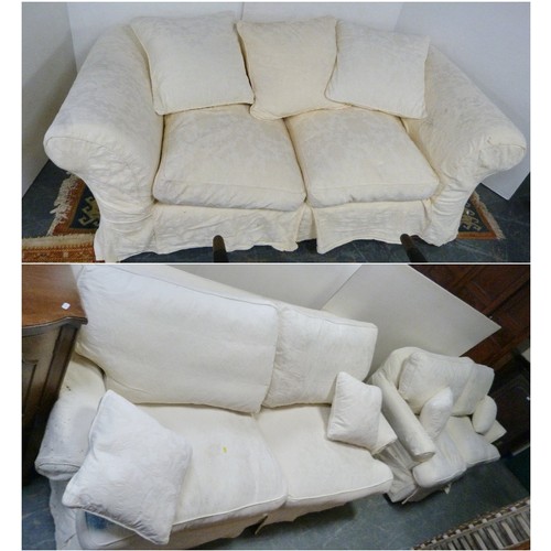 194 - Suite of three two-seater cream upholstered sofas.