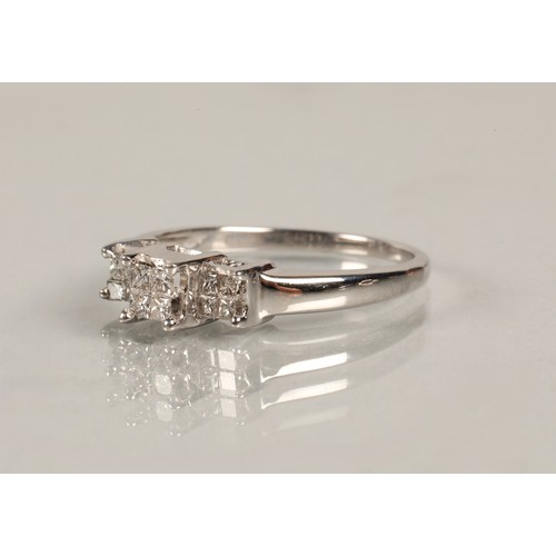 82 - Ladies diamond ring set in three groups of square cut diamonds, set on white metal shank, ring size ... 