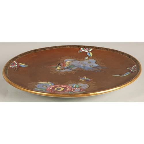 16 - Carlton ware charger in the New Chinese Bird & Cloud pattern, dark brown ground decorated with s... 