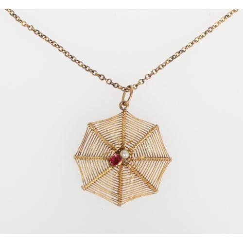 576 - Yellow metal spider pendant, the spider with small ruby and seed pearl on a web backing, on 9ct gold... 