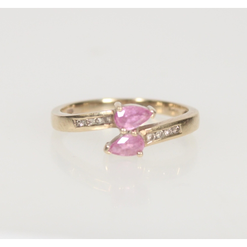 584 - 9ct gold and pink stone crossover ring, the two principal pear cut stones flanked by small diamonds,... 