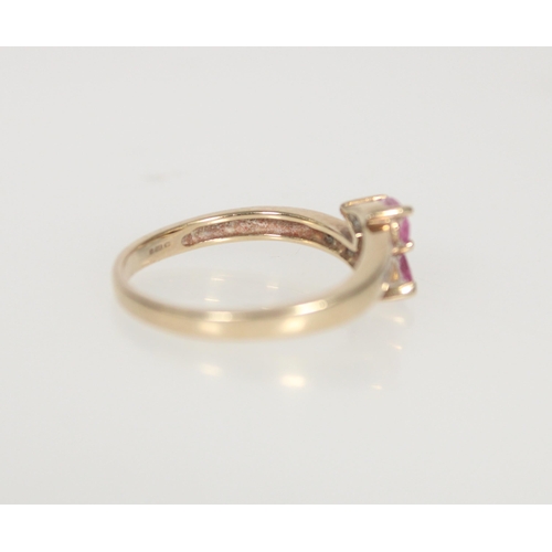 584 - 9ct gold and pink stone crossover ring, the two principal pear cut stones flanked by small diamonds,... 