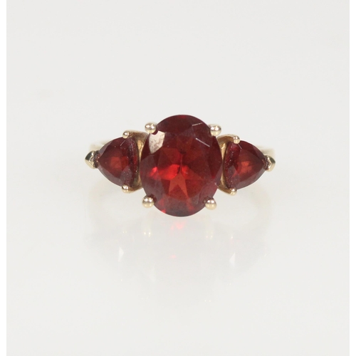 587 - 9ct gold and garnet three stone ring, principal stone 10mm x 8mm, size M/N, 3.1g.