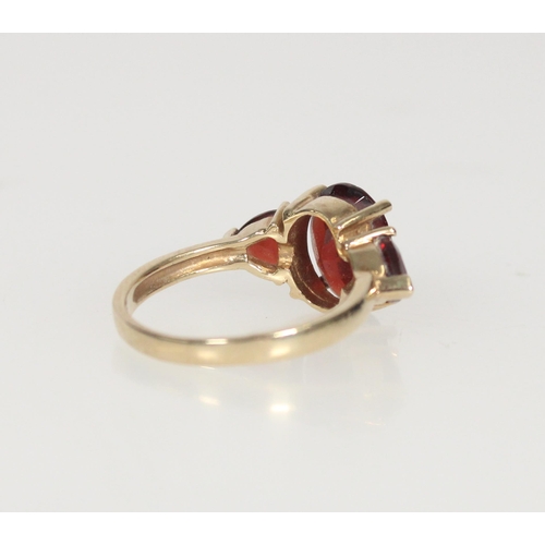 587 - 9ct gold and garnet three stone ring, principal stone 10mm x 8mm, size M/N, 3.1g.