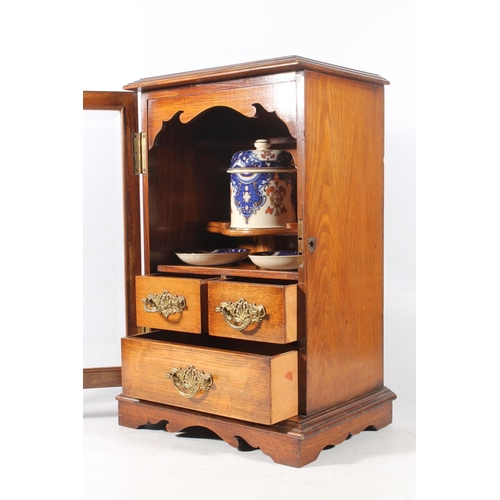 15 - Edwardian oak cased smoker cabinet with glazed front, 43cm high.