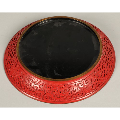 36 - Chinese cinnabar lacquered plate, relief decorated with Chinese garden, 25cm diameter.