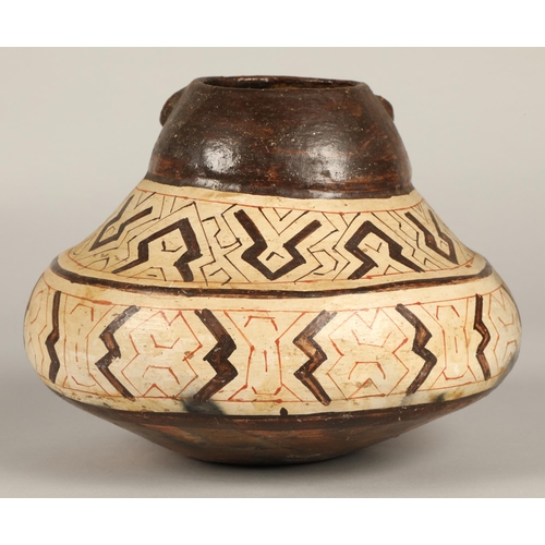 21 - Shipibo terracotta pottery vessel, 20th C, geometric patterns in brown and red surround a face with ... 