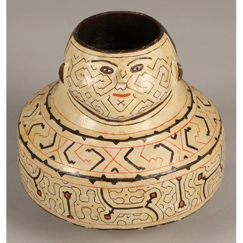 27 - Shipibo terracotta pottery vessel, 20th C, geometric patterns in brown and red surround a face with ... 