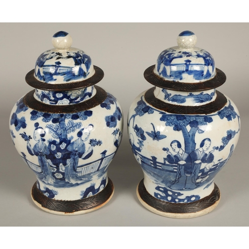 34 - Pair of Chinese glazed blue and white vases with covers, decorated with figures in a garden, 36cm hi... 