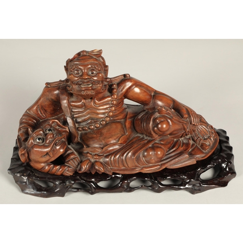 38 - Japanese root carving of Deity with dog of foo, 39cm long, 21cm high