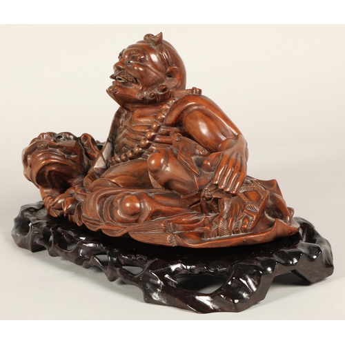 38 - Japanese root carving of Deity with dog of foo, 39cm long, 21cm high