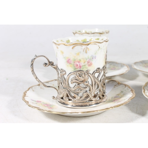 112 - Four Royal Vienna porcelain chocolate cups in hallmarked silver cup holders, and saucers.