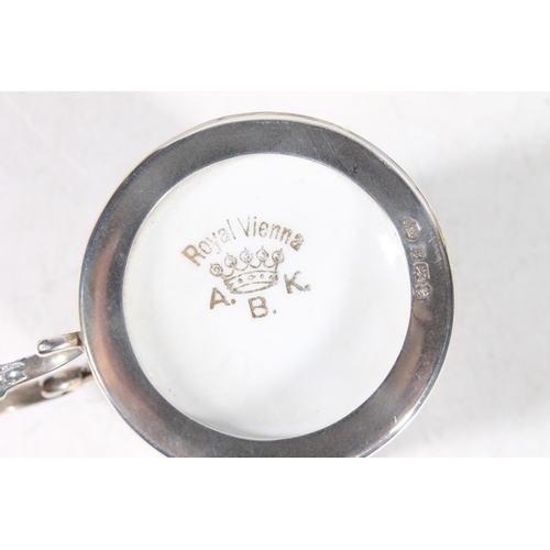 112 - Four Royal Vienna porcelain chocolate cups in hallmarked silver cup holders, and saucers.