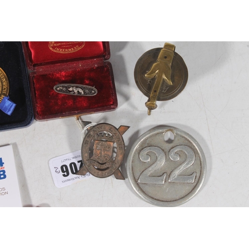 117 - Coins, medallions, cap badges, Victorian brass cup weights, a silver bear brooch, etc.