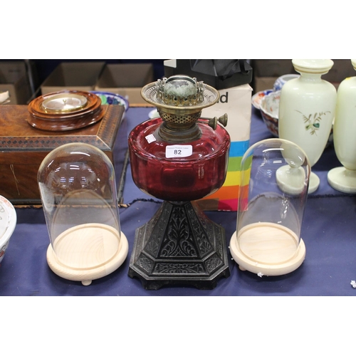 82 - Late Victorian oil lamp with cranberry glass reservoir and two display stands.