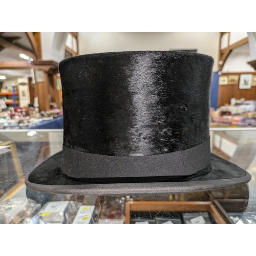 53 - Top hat in original leather hat box and a bowler hat.