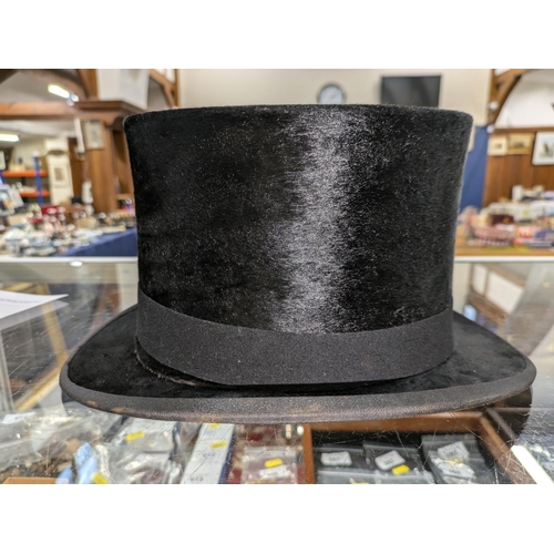 53 - Top hat in original leather hat box and a bowler hat.