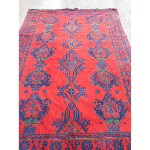 395 - Turkish red ground wool Ushak carpet having four central medallions and flanked by five guls. 250cm ... 