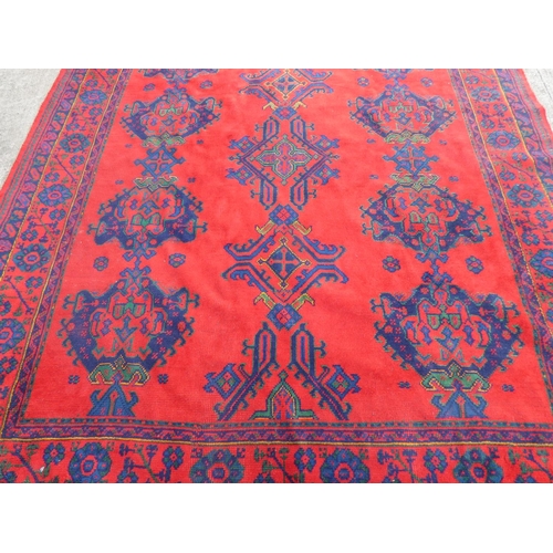 395 - Turkish red ground wool Ushak carpet having four central medallions and flanked by five guls. 250cm ... 