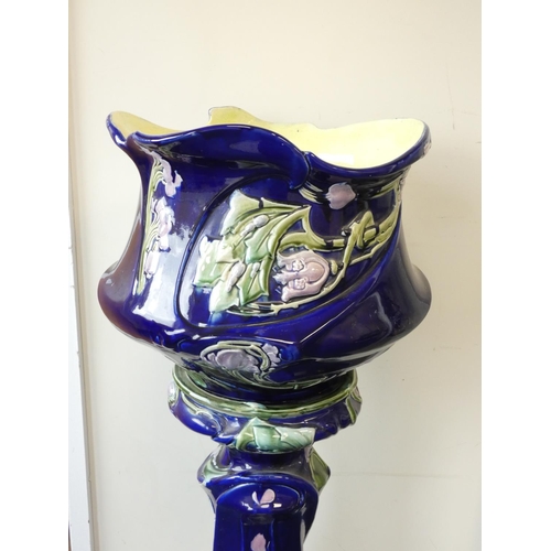 400 - Art Nouveau majolica pottery jardiniere and stand finished in a blue slip glaze and decorated with b... 