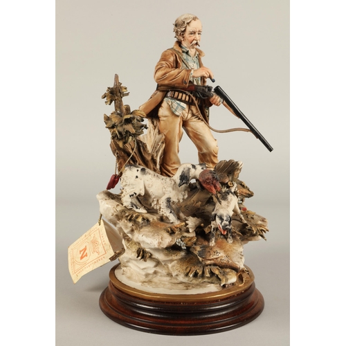 24 - Capodimonte figure of a hunter, two dogs and birds on naturalistic base.