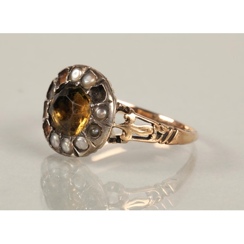 60 - Yellow metal ring set with a yellow stone possibly citrine, surrounded by seed pearls (some missing)... 