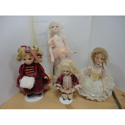 83 - Four bisque china dolls, in assorted dress.  (4)