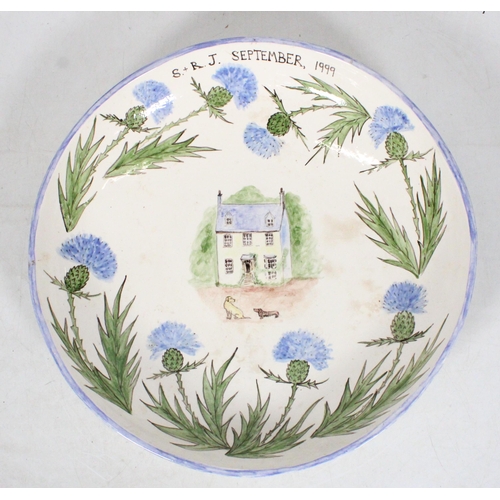 35 - Studio Pottery bowl painted with blue thistles around cottage scene, 37cm.