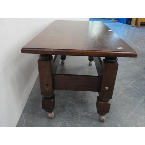 443 - Oak coffee table on castors and an oval wall mirror.  (2)